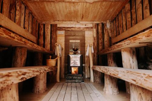 a fireplace in a log cabin with wooden walls at Cabana Bucin in Bucsin