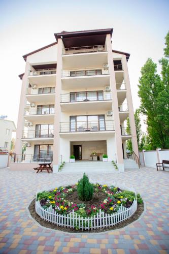 a large building with a flower bed in front of it at Villa San-Marina in Zatoka