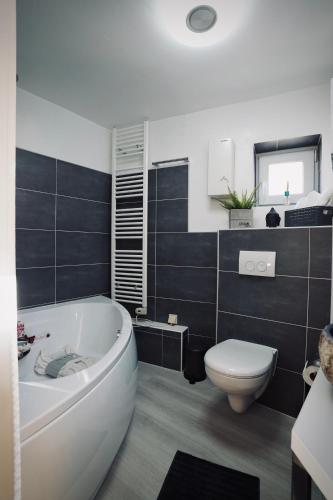 a bathroom with a white tub and a toilet at Tinytimeout Westerwald in Ellar