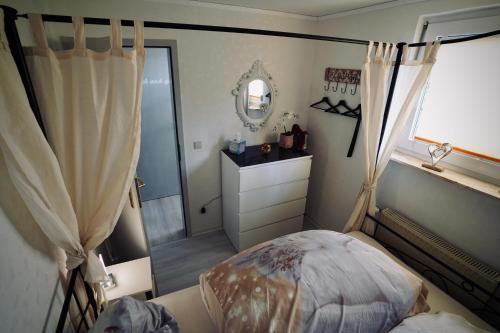 a bedroom with a bed and a mirror and a dresser at Tinytimeout Westerwald in Ellar