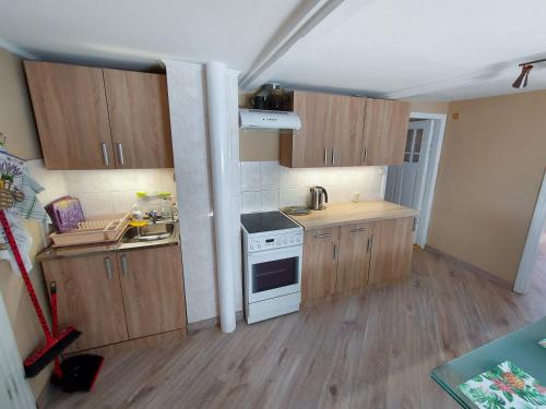 a small kitchen with wooden cabinets and a stove at Jaunklāvi in Sīkrags