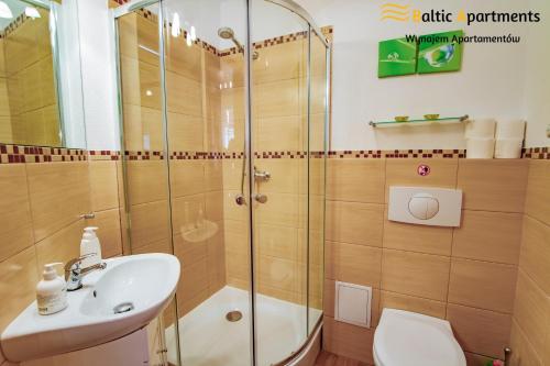 łazienka z prysznicem, umywalką i toaletą w obiekcie Baltic Apartments - Rezydencja Bursztyn w Świnoujściu