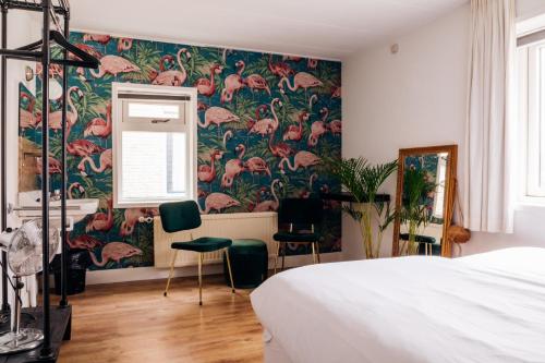 a bedroom with a floral wallpaper with pink flamingos at Fris. in Cadzand
