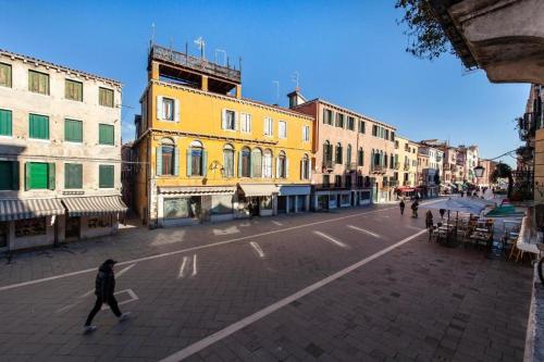 a person crossing a street in a city at Appartamenti Superior in Via Garibaldi by Bricola Apartments in Venice