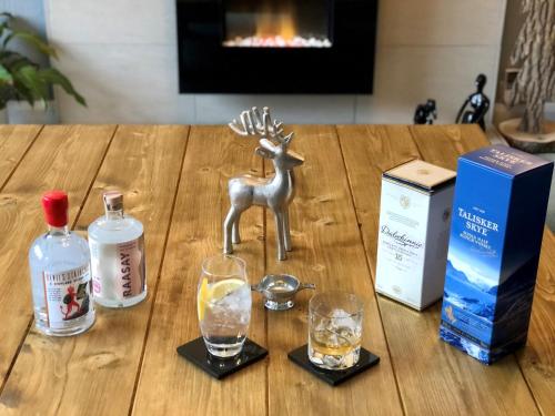 a table with glasses and a statue of a deer on it at Distant Hills Guest House in Spean Bridge