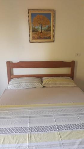 a bed in a bedroom with a picture on the wall at Pousada Sossego da Vila - Trindade Paraty in Trindade