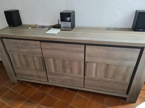 a wooden dresser with a speaker on top of it at APT 65 M2 DANS VILLA AVEC PISCINE BANYULS SUR MER in Banyuls-sur-Mer
