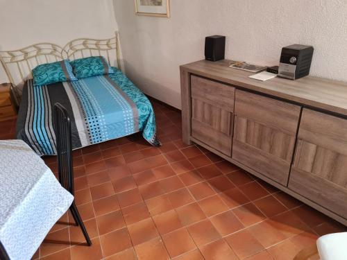 a bedroom with a bed and a wooden dresser at APT 65 M2 DANS VILLA AVEC PISCINE BANYULS SUR MER in Banyuls-sur-Mer