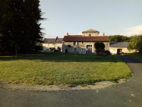 een oud huis op een grasveld naast een weg bij La Tour du Raygnier in Verneuil-le-Château