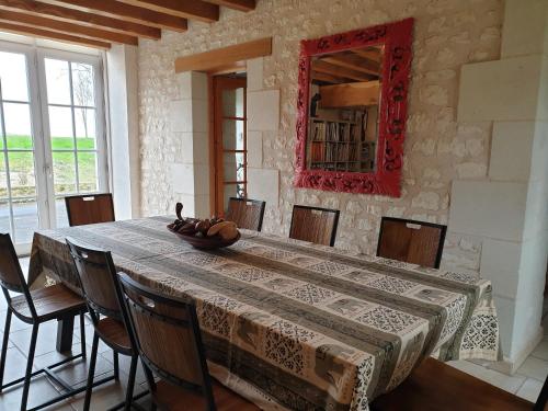 een eetkamer met een tafel met stoelen en een spiegel bij La Tour du Raygnier in Verneuil-le-Château