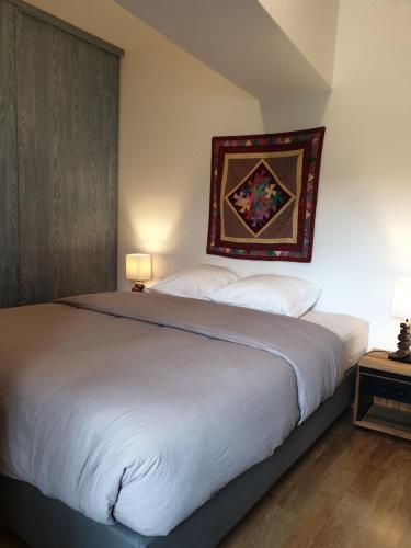 a bedroom with a large bed with a rug on the wall at La Tour du Raygnier in Verneuil-le-Château