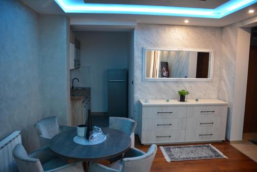 Una cocina con una mesa y sillas y un fregadero. en MONA RELAX, en Vrnjačka Banja