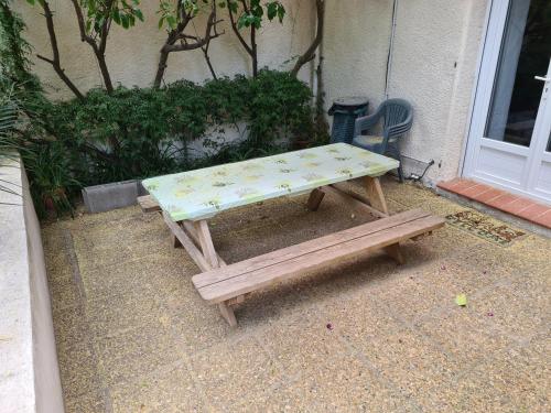 a picnic table and a bench in front of a house at APT 65 M2 DANS VILLA AVEC PISCINE BANYULS SUR MER in Banyuls-sur-Mer