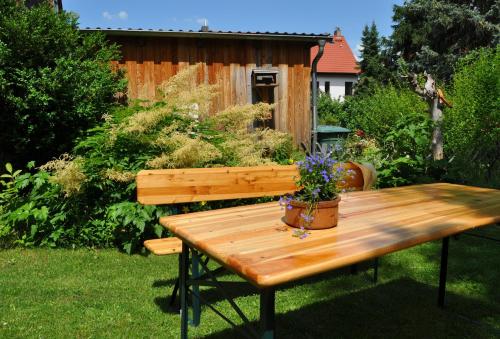 a wooden picnic table with a potted plant on it at Goethestraße 9 in Ballenstedt