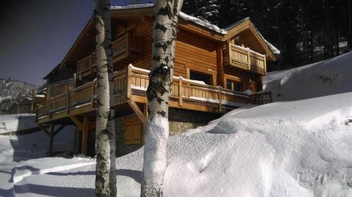 a log cabin in the snow with a pile of snow around it at Chalet Les Sorbiers in Égat