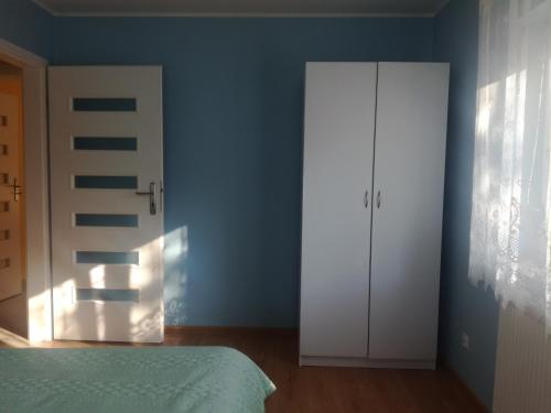 a bedroom with a bed and a white door at Zaciszny Zakątek in Drohiczyn nad Bugiem