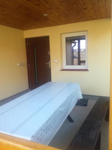 a large white bed in a room with a window at Zaciszny Zakątek in Drohiczyn nad Bugiem