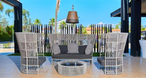 a patio with two chairs and a couch and a table at Hotel Cerere in Paestum