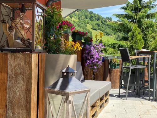a patio with a table and flowers and a lamp at Hotel Residenz Hochalm - Joker Card Partner in Saalbach Hinterglemm
