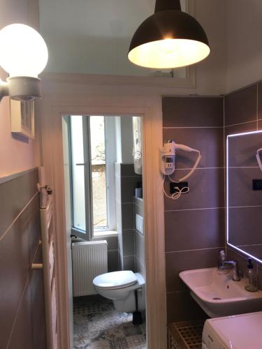 a bathroom with a toilet and a sink and a light at apartment Tiziano-Belveder with private garage in Rijeka