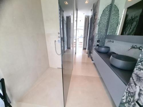 a bathroom with two sinks and a walk in shower at Suiten-Aparthotel AENEA in Reifnitz