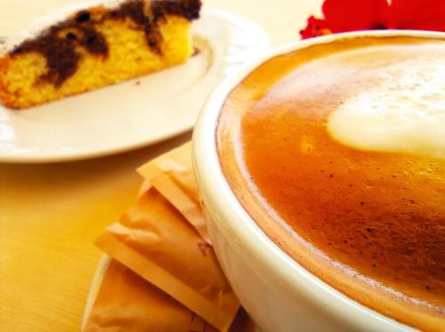a cup of coffee and a piece of cake on a table at Baja Azzurra in Bari Sardo