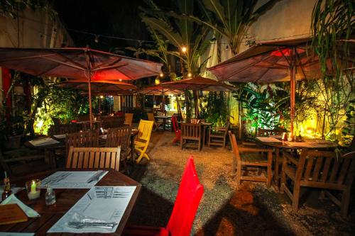a restaurant with tables and chairs and umbrellas at Pousada Bartholomeu in Paraty