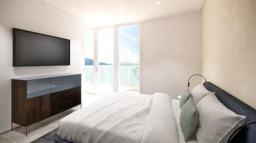 a bedroom with a bed and a television on a wall at Suiten-Aparthotel AENEA in Reifnitz