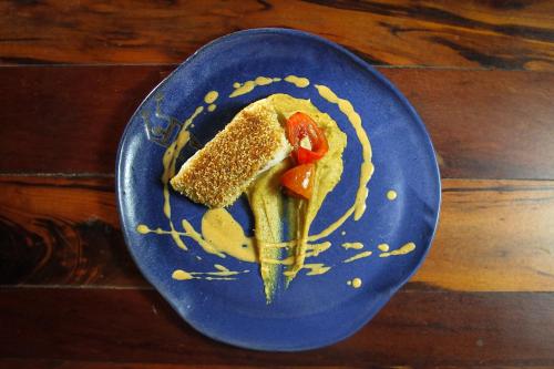 a blue plate with food on a wooden table at Pousada Bartholomeu in Paraty
