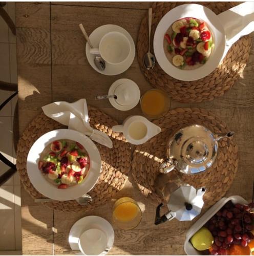 a table with plates and bowls of food and drinks at Howlong Old Post Office Luxury Suite in Howlong