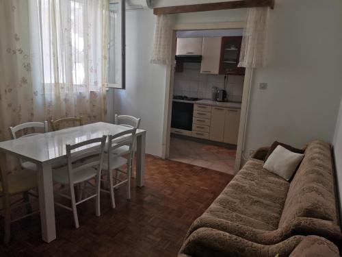 a living room with a table and a couch at Apartman Niko Promajna in Promajna