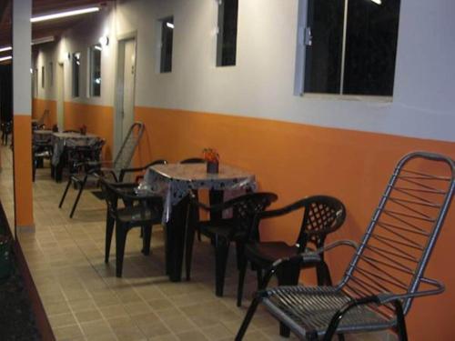 a restaurant with tables and chairs in a room at Pousada Sol Nascente in Olímpia
