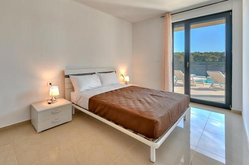 a bedroom with a bed and a balcony at Pure in Medulin