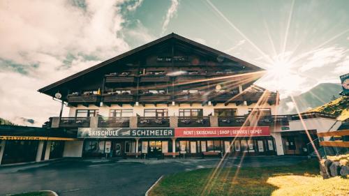 a large building with the sun in the background at Appartementhaus Am Gschwandtkopf in Seefeld in Tirol