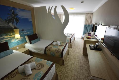 a hotel room with two beds and a flat screen tv at Hotel Izgrev Spa & Aquapark in Struga