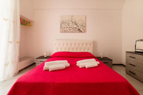 a bedroom with a red bed with two pillows on it at Casa Fiordaliso - Puglia Mia Apartments in Monopoli