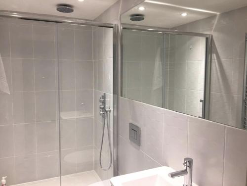 a bathroom with a shower and a sink and a mirror at Central London Charming Camden Split Level Home in London