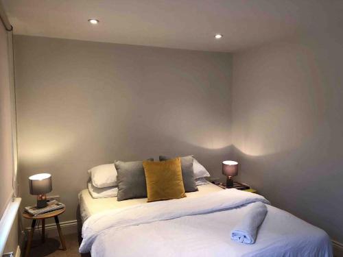 1 dormitorio con 1 cama grande y 2 lámparas en Central London Charming Camden Split Level Home, en Londres