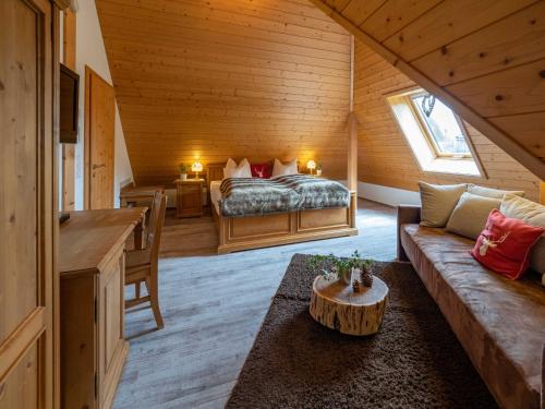 ein Zimmer mit einem Bett und einem Sofa in einer Hütte in der Unterkunft Holiday Apartements by Hotel Grüner Baum Feldberg in Feldberg