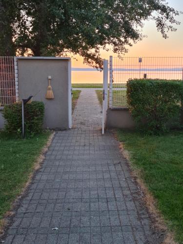 a walkway leading to a fence with a lamp on it at EDA Beach Apartman in Siófok