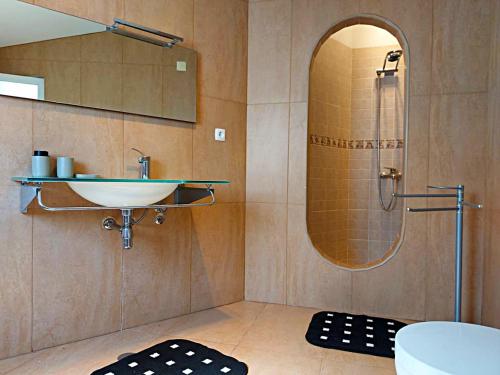 a bathroom with a sink and a shower with a mirror at Quinta do Chaparrinho in Sardoal