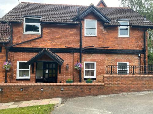 a red brick house with a black roof at The lodge at Carlton tavern free parking in York