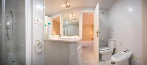 Baño blanco con lavabo y aseo en Caminito del Falla B Ha Apartment, en Cádiz