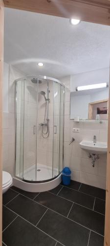 a bathroom with a shower and a toilet and a sink at Gasthof zum Rassen in Garmisch-Partenkirchen