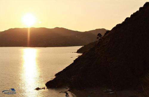 a person riding a bike next to a body of water at Nuraghe Apartments in Teulada
