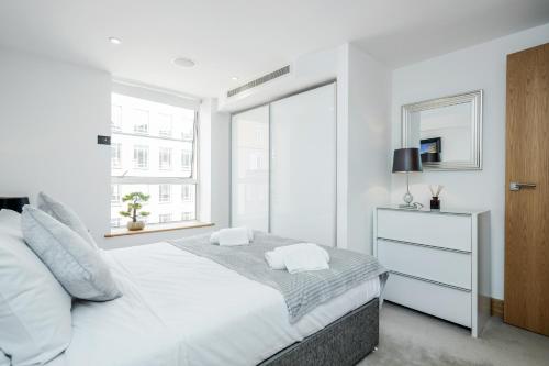 a white bedroom with a white bed and a window at Luxury 3 Bed 2 Bath Apartment Marylebone Station in London