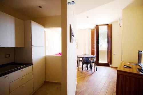 a kitchen and a dining room with a table at Nuraghe Apartments in Teulada