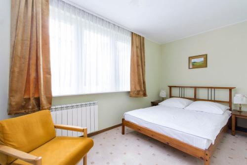 sypialnia z łóżkiem, krzesłem i oknem w obiekcie Apartament Nadmorski Wyspa Sobieszewska w Gdańsku
