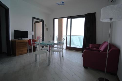 a living room with a glass table and a couch at Nuraghe Apartments in Teulada