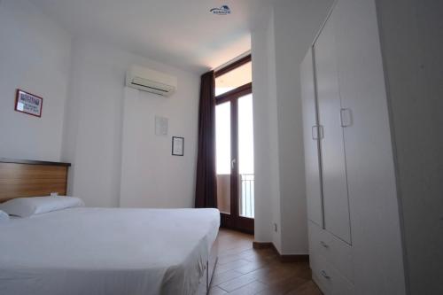 a bedroom with a white bed and a window at Nuraghe Apartments in Teulada